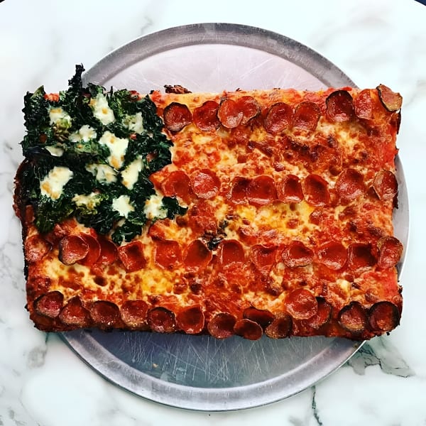 Rectangular pepperoni pizza topped with melted cheese and a leafy green vegetable section on a metal serving tray.