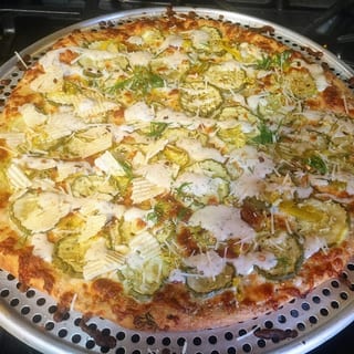 PORTLAND our delicious fried pickle pizza!  Ranch or White Garlic base, dill pickle chips dusted & deep fried in our tasty fried chicken coating atop our award winning dough and finished with 100% mozzarella cheese, cheddar, parmesan & parsley